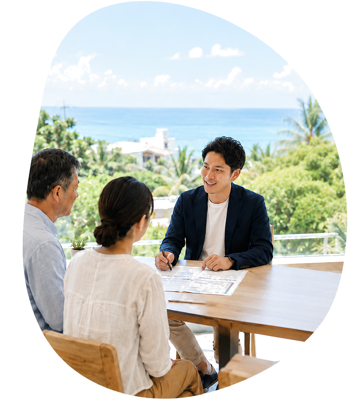 沖縄の海を背景にご家族で不動産相談をするシーン